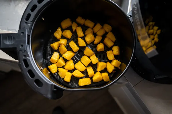 Cubes of polenta in an air fryer basket.