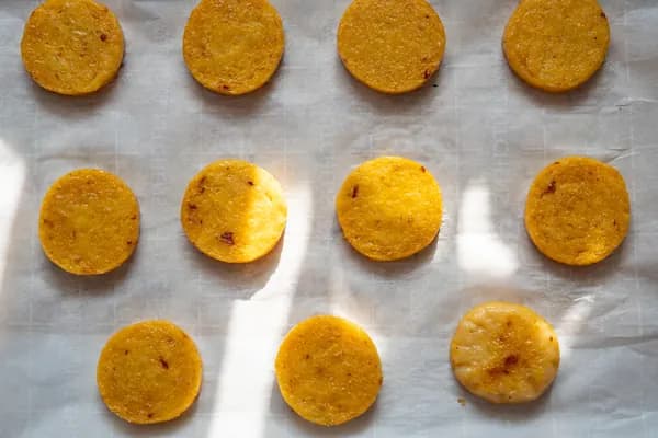 Polenta rounds on a parchment-lined baking sheet.