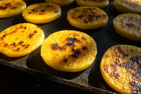 Golden polenta rounds on a griddle.